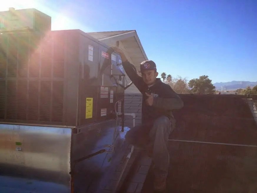 HVAC technician performing HVAC Inspection on a rooftop unit in Emmett